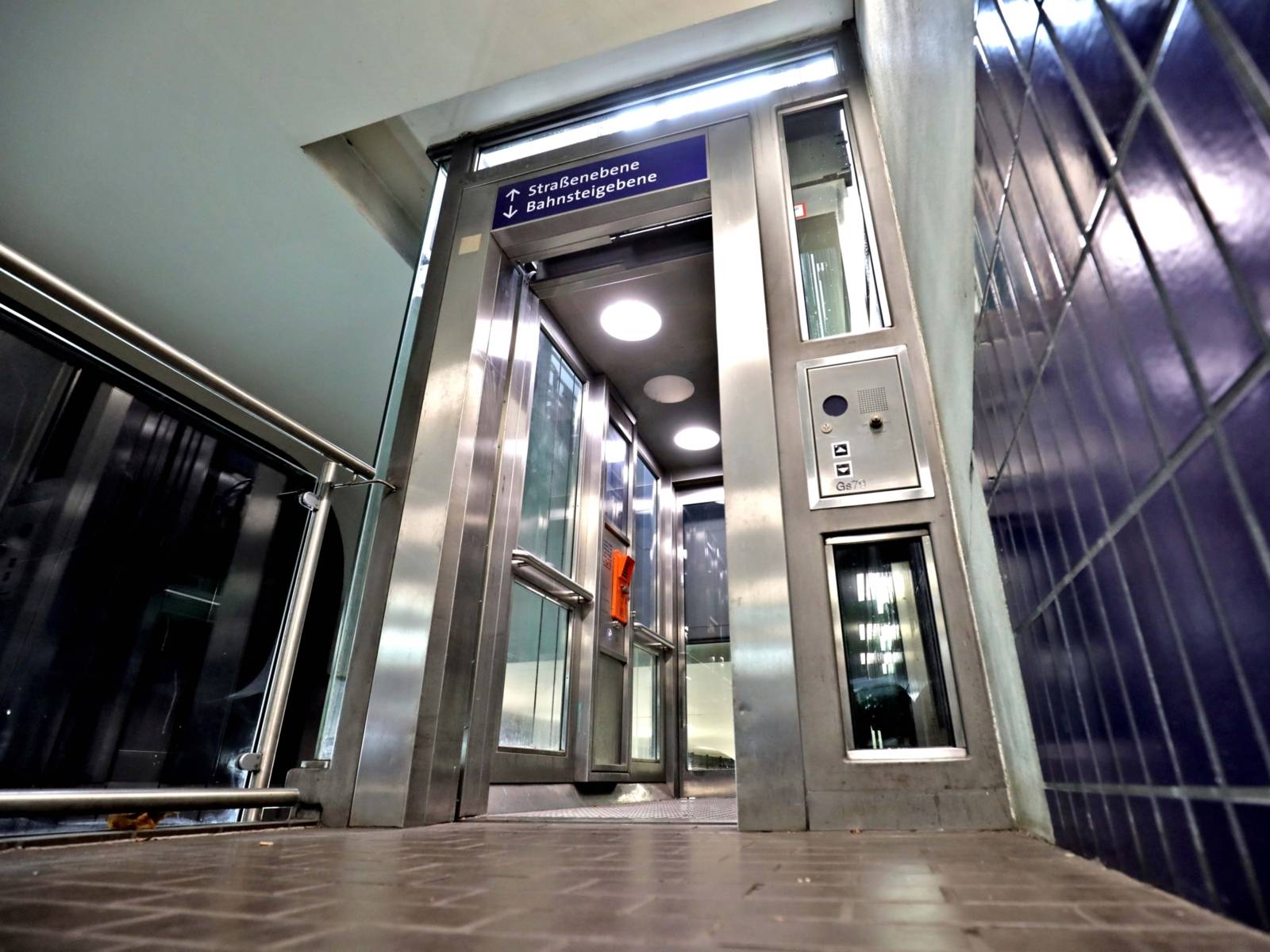 Der Aufzug an der Station Lister Platz mit offenen Türen in der unterirdischen Stadtbahnstation aus der Froschperspektive fotografiert.