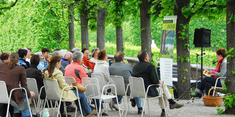 Eine Gruppe Menschen bei einer Lesung im Großen Garten